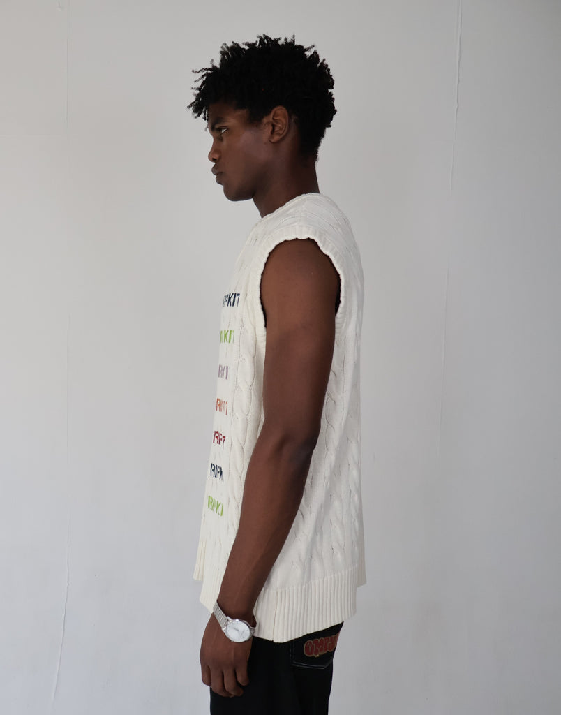 Model wearing an oversized white cable-knit cotton vest with multicolor "The Dripkit" embroidery, sleeveless streetwear design ideal for summer layering, casual outfits, and unisex fashion.

cotton 
vest
white 
knitted 
oversized 
summer 
vacation
holiday
streetwear 
minimalist fashion
trendy vest 2025
casual layering 
gender-neutral 
modern tyle
everyday essential
breathable 
sustainable 
eco-friendly
skin-friendly 
buy 
trendy
seasonal
OOTD
outfit of the day
bold
statement
capsule
limited edition
