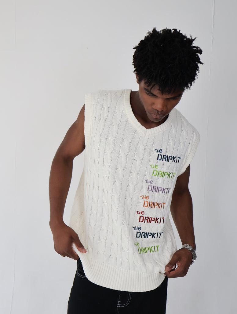 Model wearing an oversized white cable-knit cotton vest with multicolor "The Dripkit" embroidery, sleeveless streetwear design ideal for summer layering, casual outfits, and unisex fashion.

cotton 
vest
white 
knitted 
oversized 
summer 
vacation
holiday
streetwear 
minimalist fashion
trendy vest 2025
casual layering 
gender-neutral 
modern tyle
everyday essential
breathable 
sustainable 
eco-friendly
skin-friendly 
buy 
trendy
seasonal
OOTD
outfit of the day
bold
statement
capsule
limited edition
