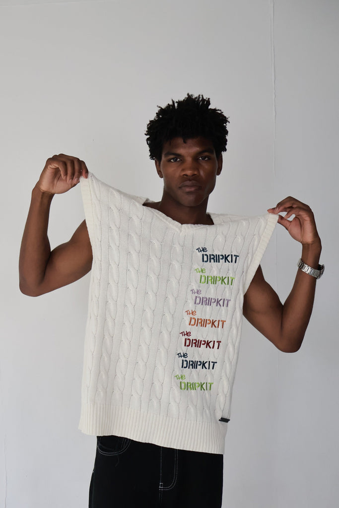 Model wearing an oversized white cable-knit cotton vest with multicolor "The Dripkit" embroidery, sleeveless streetwear design ideal for summer layering, casual outfits, and unisex fashion.

cotton 
vest
white 
knitted 
oversized 
summer 
vacation
holiday
streetwear 
minimalist fashion
trendy vest 2025
casual layering 
gender-neutral 
modern tyle
everyday essential
breathable 
sustainable 
eco-friendly
skin-friendly 
buy 
trendy
seasonal
OOTD
outfit of the day
bold
statement
capsule
limited edition